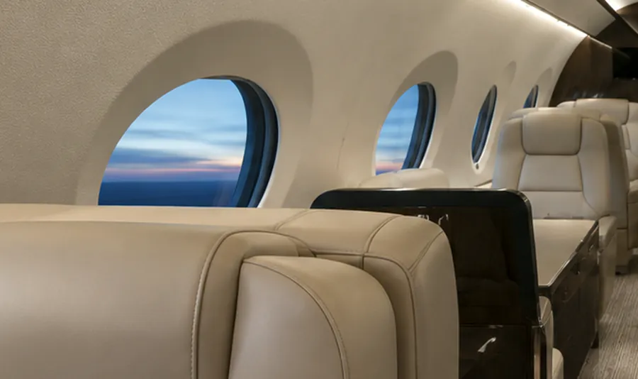 Cabin windows and window reveals inside a business jet with evening light outside